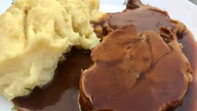 Traditionelles Sauerbraten Rezept mit mariniertem Rindfleisch, serviert mit Rotkohl und Knödeln