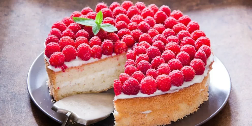 Frischer Himbeer-Schmand-Kuchen mit goldbraunem Boden und saftigen Himbeeren als Topping.