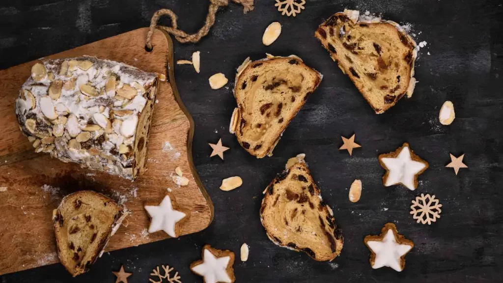 Traditioneller Christstollen in Stücke geschnitten auf einem Holzbrett