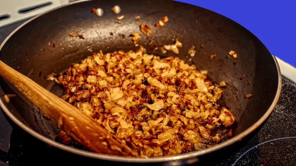 Zwiebelrostbraten in der Pfanne – Saftiges Rindersteak mit goldbraunen Zwiebeln in einer heißen Pfanne.