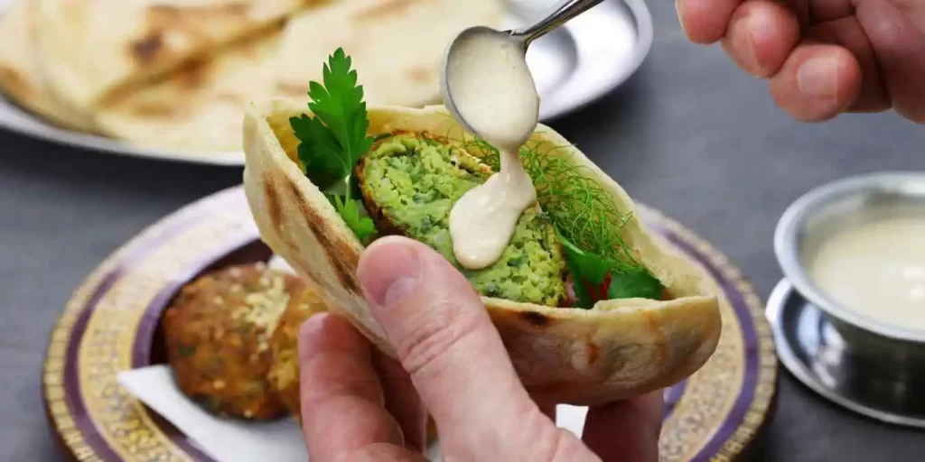 Frische Falafel im Fladenbrot, garniert mit knackigem Gemüse und Tahini-Soße