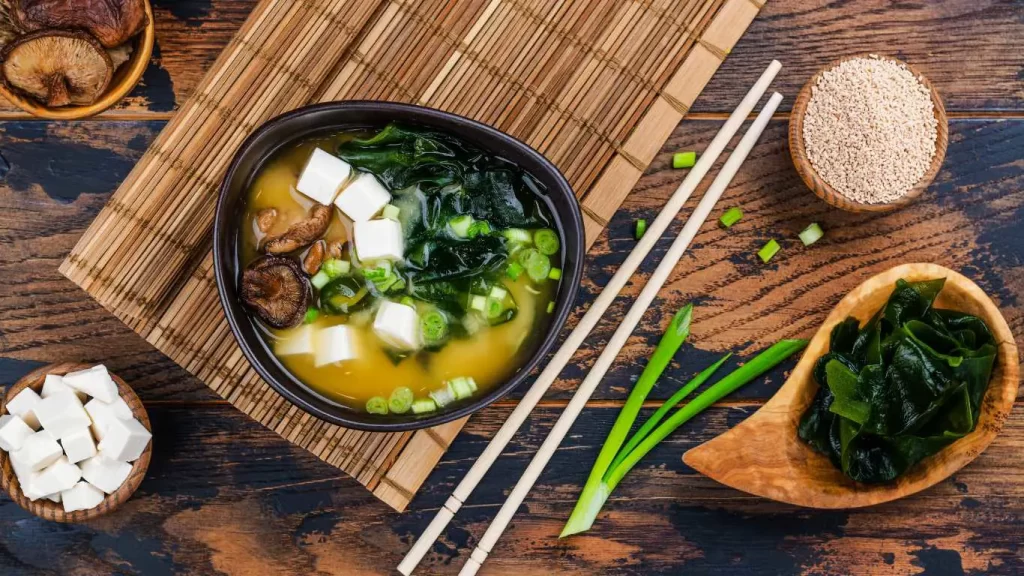 Klassische Miso Suppe in einer Schale, serviert mit Tofu, Seetang und Frühlingszwiebeln.