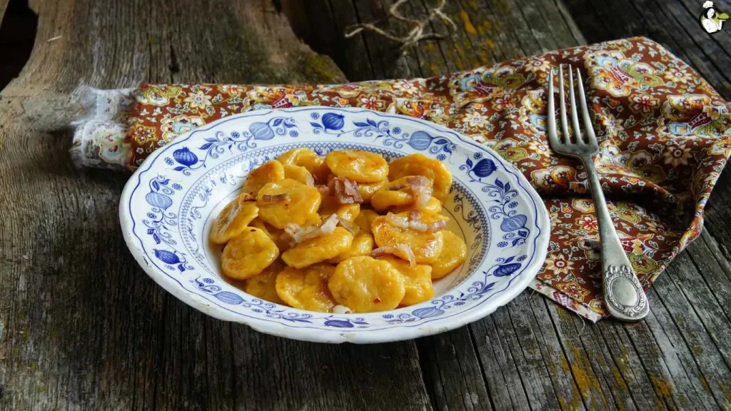 Leckere Kürbis-Gnocchi serviert in einer cremigen Salbei-Butter-Sauce, garniert mit Parmesan und frischen Kräutern.