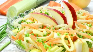 Frischer Apfel-Karotten-Salat mit knackigen Äpfeln, geraspelten Karotten und einer leichten Zitronen-Dressing.