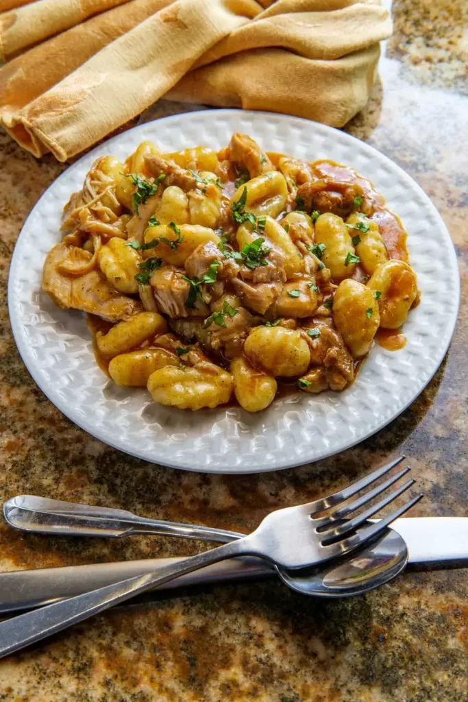 Einfache Gnocchi mit Hähnchen in einer leichten Tomaten-Sahnesauce, serviert auf einem Teller