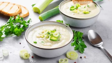 Vegetarische Käse-Lauch-Suppe in einer Schüssel, garniert mit frischen Kräutern