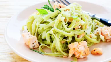 Selbstgemachte Omas Nudeln mit frischem Lachs, angerichtet auf einem weißen Teller.