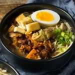 Schüssel mit dampfendem vegetarischem Ramen, frischem Gemüse und Nudeln in aromatischer Brühe