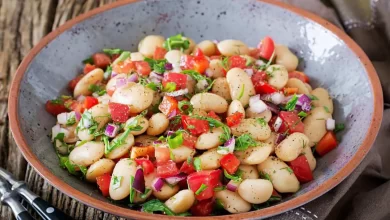 Salat aus weißen Bohnen mit frischen Tomaten, Gurken, roten Zwiebeln und einem würzigen Kräuterdressing