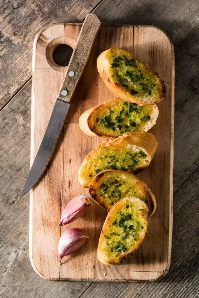 Traditionelles Knoblauchbrot mit knuspriger Kruste, bestrichen mit Knoblauchbutter und frischen Kräutern