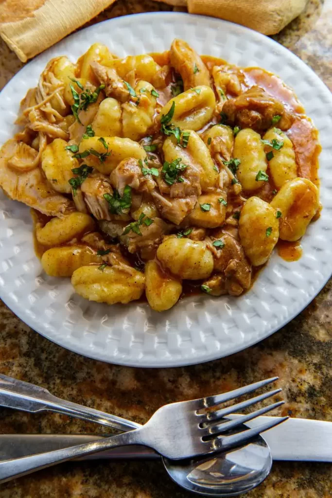 Traditionelles Gnocchi mit Hähnchen in einer hausgemachten Tomatensauce, serviert in einer rustikalen Schüssel