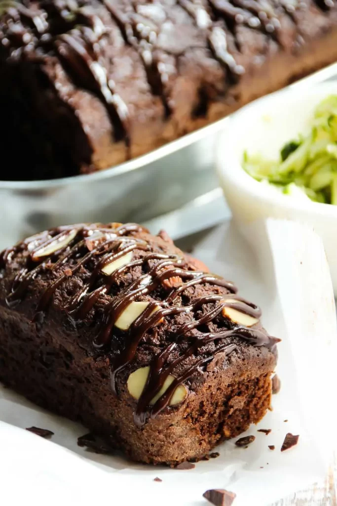 Veganer Schoko Zucchini Kuchen, saftig und schokoladig, mit pflanzlichen Zutaten und geriebener Zucchini, serviert auf einem Teller