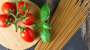 Zutaten für vegetarischen Spaghetti Salat, einschließlich frisches Gemüse, Oliven und Dressing