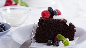 Gesunder veganer Schokokuchen, dekoriert mit Nüssen und Beeren