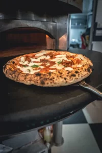 Omas frisch gebackene Neapolitanische Pizza mit luftigem Rand, aromatischer Tomatensoße und zartem Mozzarella